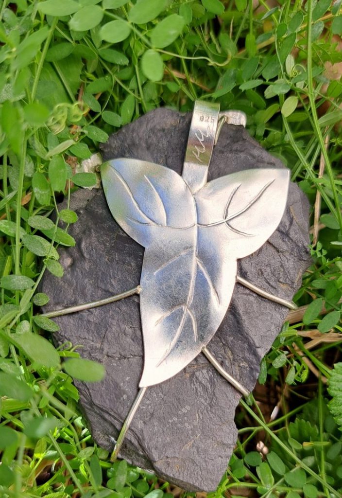 Artisans_buddies_challenge25: fertiger Anhänger aus roher Schieferplatte mit einem großen, silbernen Efeublatt auf der Rückseite